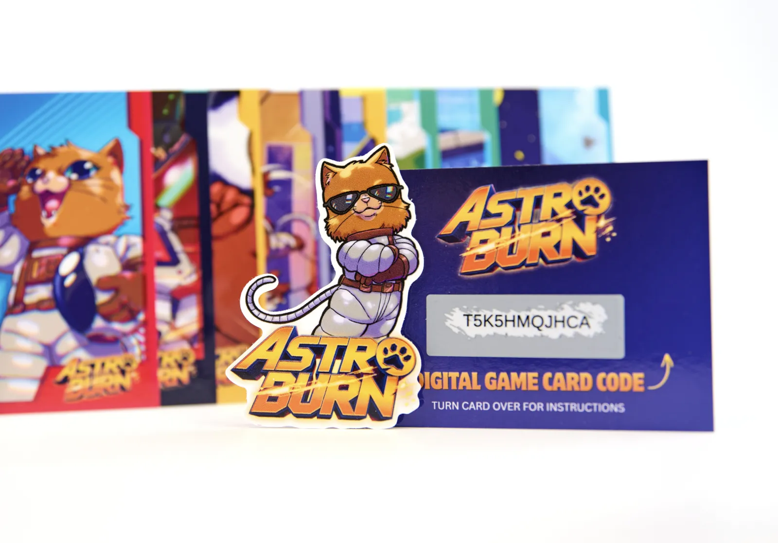 Holographic Astro Burn sticker in front of the digital game card code and art cards